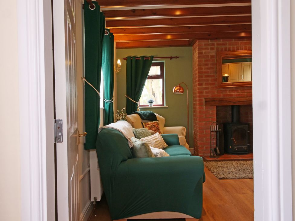 A living room with a sofa and fireplace at Chomley @ Summerfield Farm in Hawsker