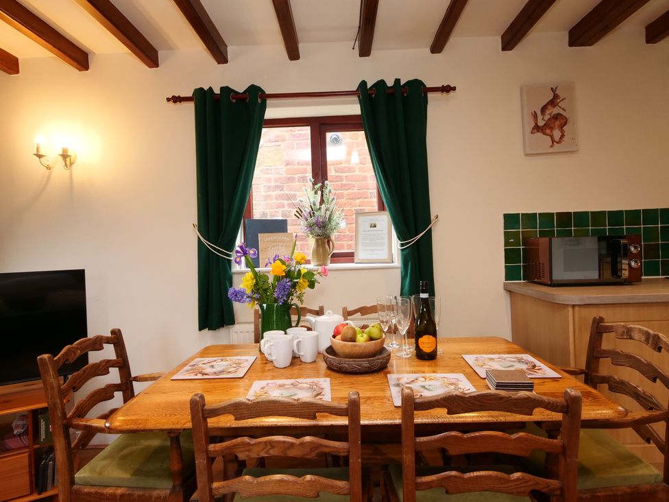 A dining room with a table and chairs at Chomley @ Summerfield Farm in Hawsker