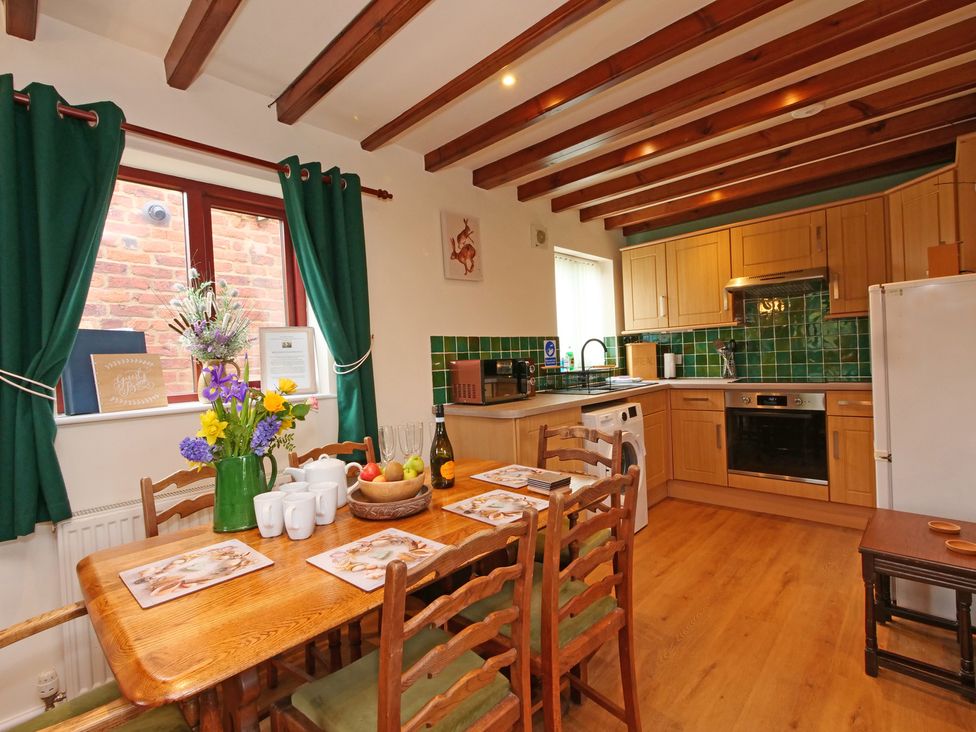 A kitchen with a dining table and chairs at Chomley @ Summerfield Farm Hawsker