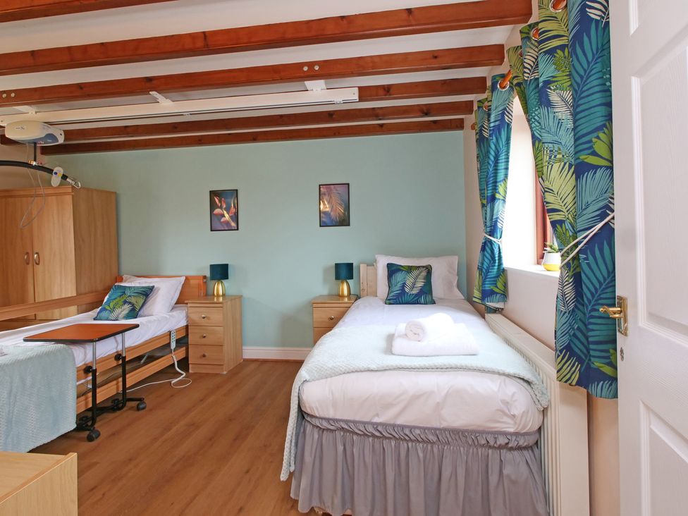 A bedroom with two beds and bedside tables at Chomley @ Summerfield Farm in Hawsker