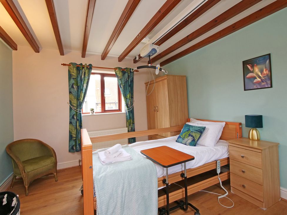 A bedroom with a bed and a bedside table at Chomley @ Summerfield Farm, Hawsker