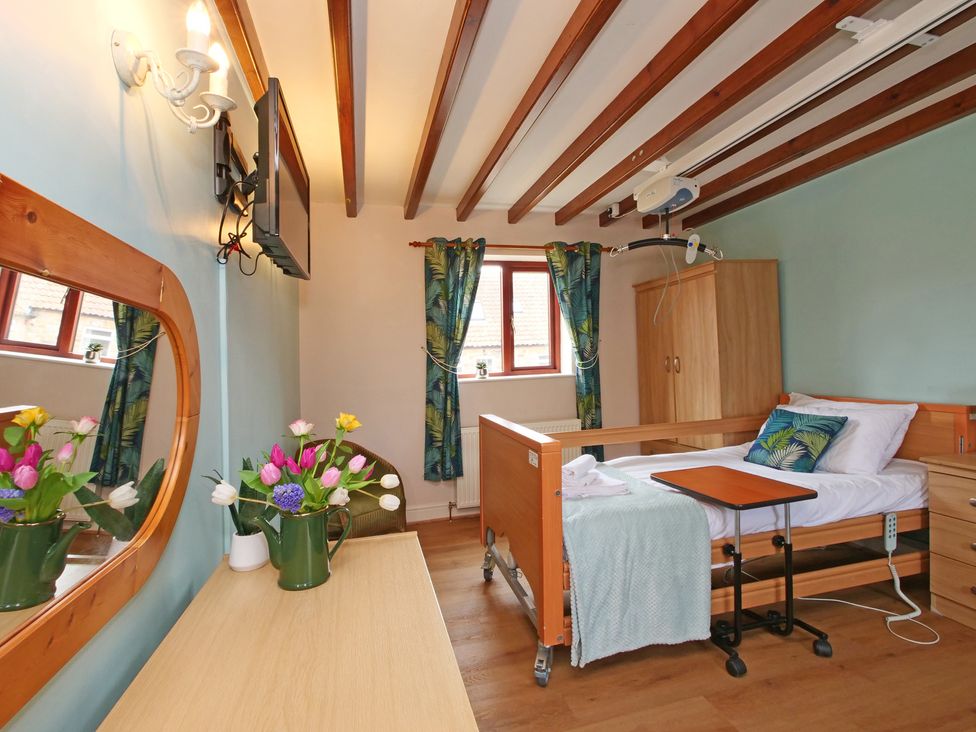 A bedroom with a hospital bed and mirror at Chomley @ Summerfield Farm in Hawsker