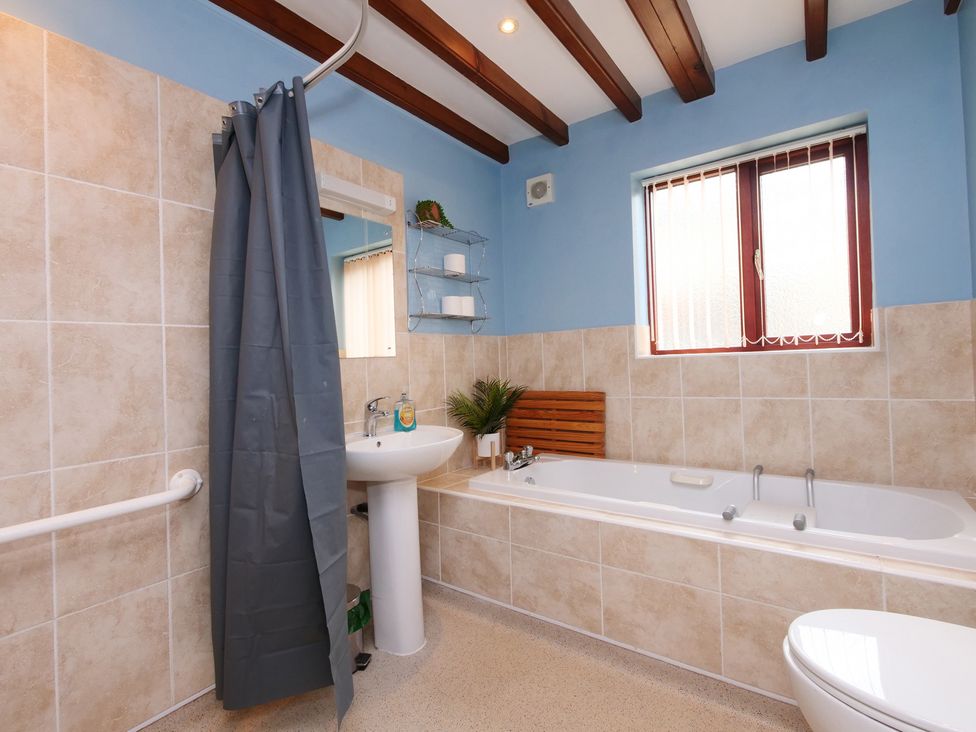 A bathroom with a bathtub, sink, and shower at Chomley @ Summerfield Farm in Hawsker