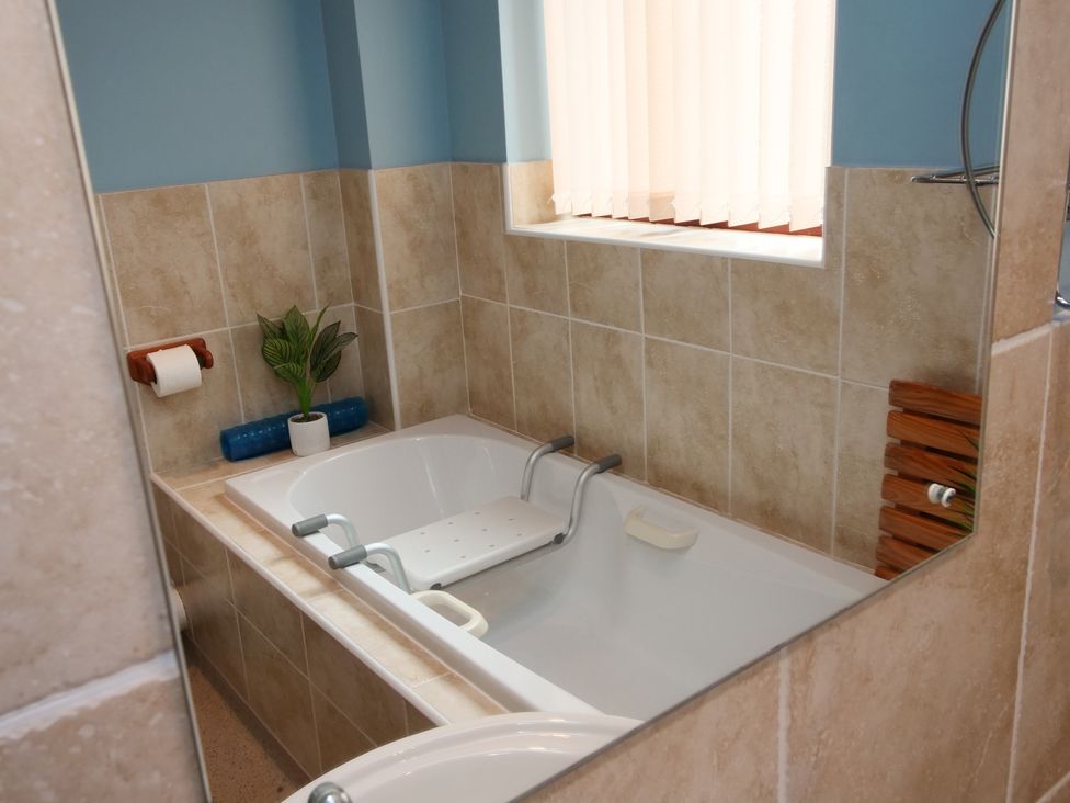 A bathroom with a bath tub and a towel holder at Chomley @ Summerfield Farm, Hawsker
