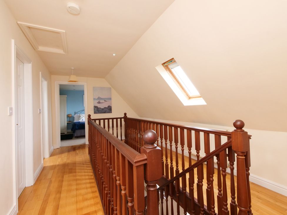 A hallway with a wooden stair railing and skylight at Chomley @ Summerfield Farm in Hawsker