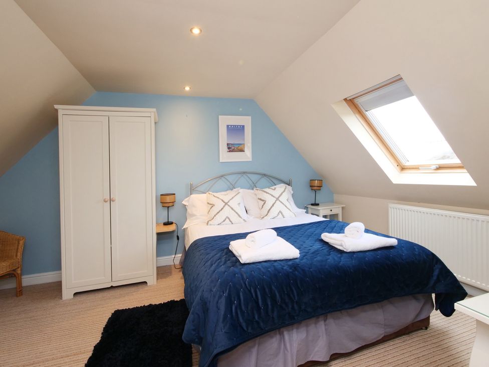 A bedroom with a bed and wardrobe at Chomley @ Summerfield Farm in Hawsker