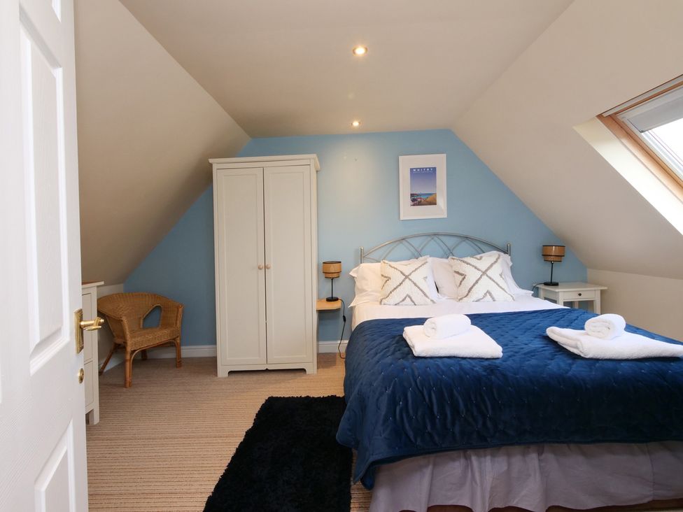 A bedroom with a bed and wardrobe at Chomley @ Summerfield Farm in Hawsker