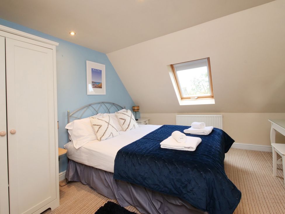 A bedroom with a bed and window at Chomley @ Summerfield Farm in Hawsker