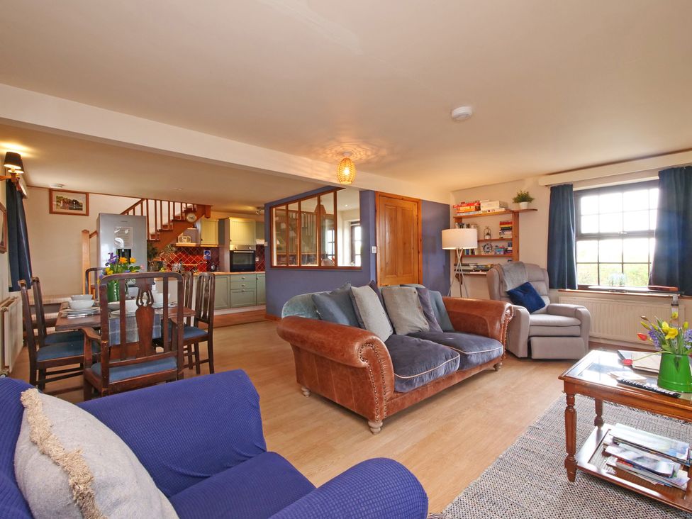 A living room with a sofa and dining area at Albany @ Summerfield Farm in Hawsker
