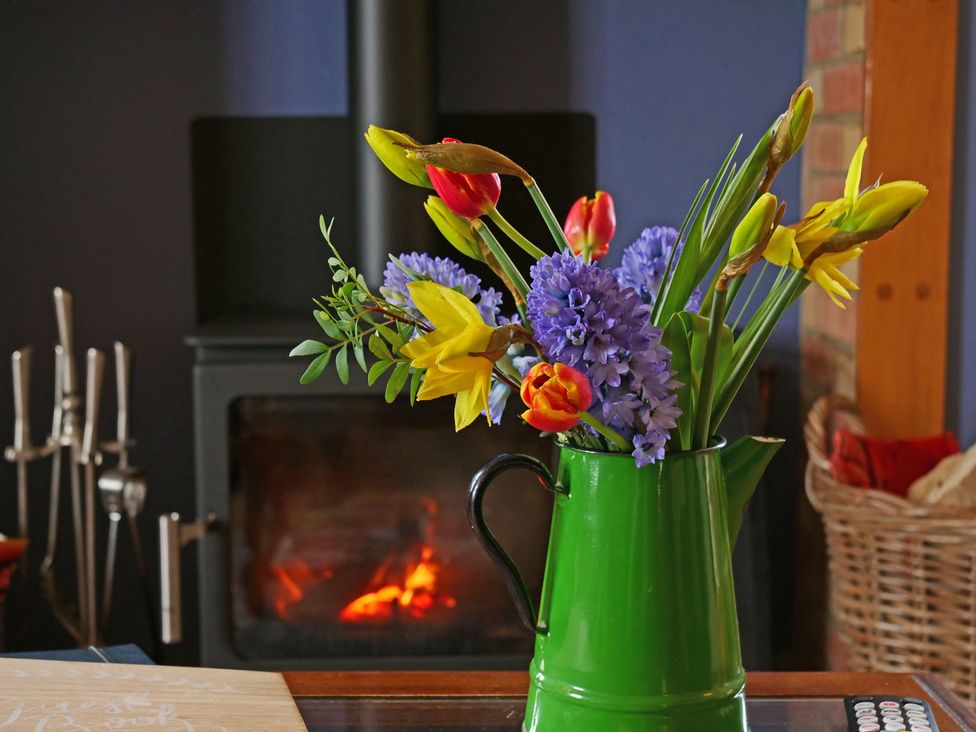 A green pitcher with flowers on a table in a living room at Albany @ Summerfield Farm, Hawsker