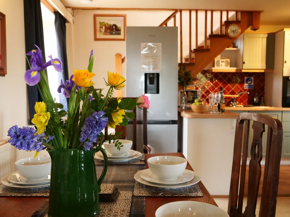 A dining room with a table set and a flower vase at Albany @ Summerfield Farm, Hawsker