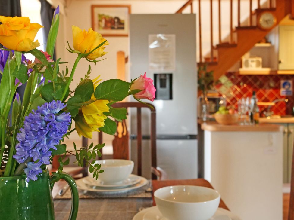 A dining room with a table set and a refrigerator in the background at Albany @ Summerfield Farm, Hawsker