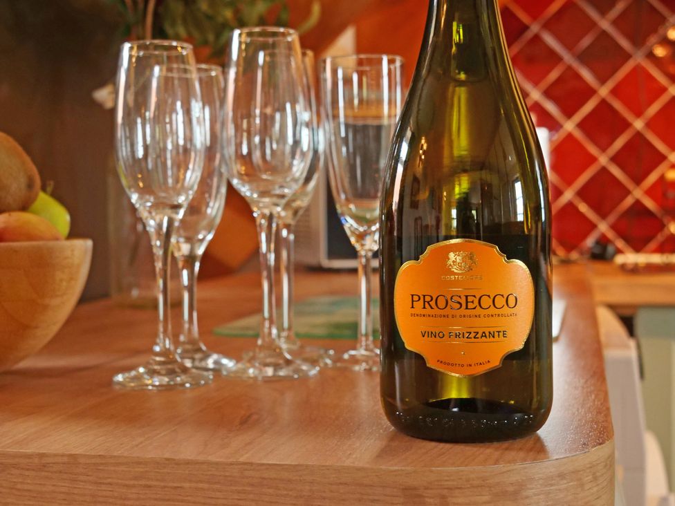 A bottle of Prosecco and glasses on a table at Albany @ Summerfield Farm in Hawsker