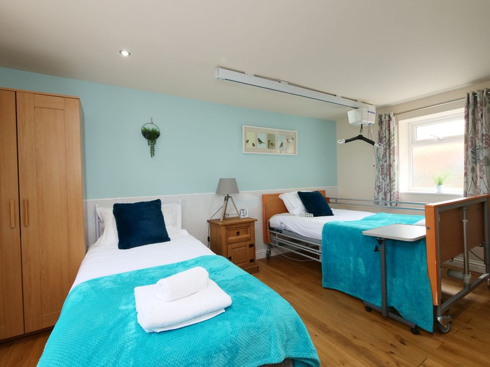 A bedroom with two beds and a window at Albany @ Summerfield Farm, Hawsker