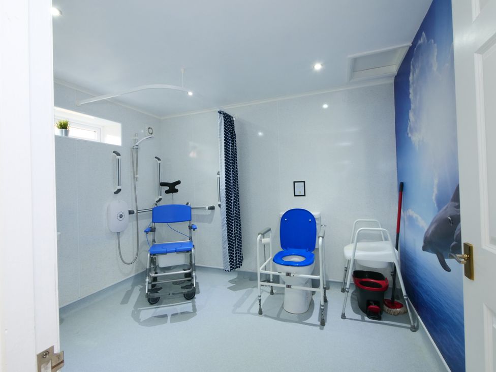 A bathroom with a shower chair and toilet at Albany @ Summerfield Farm, Hawsker