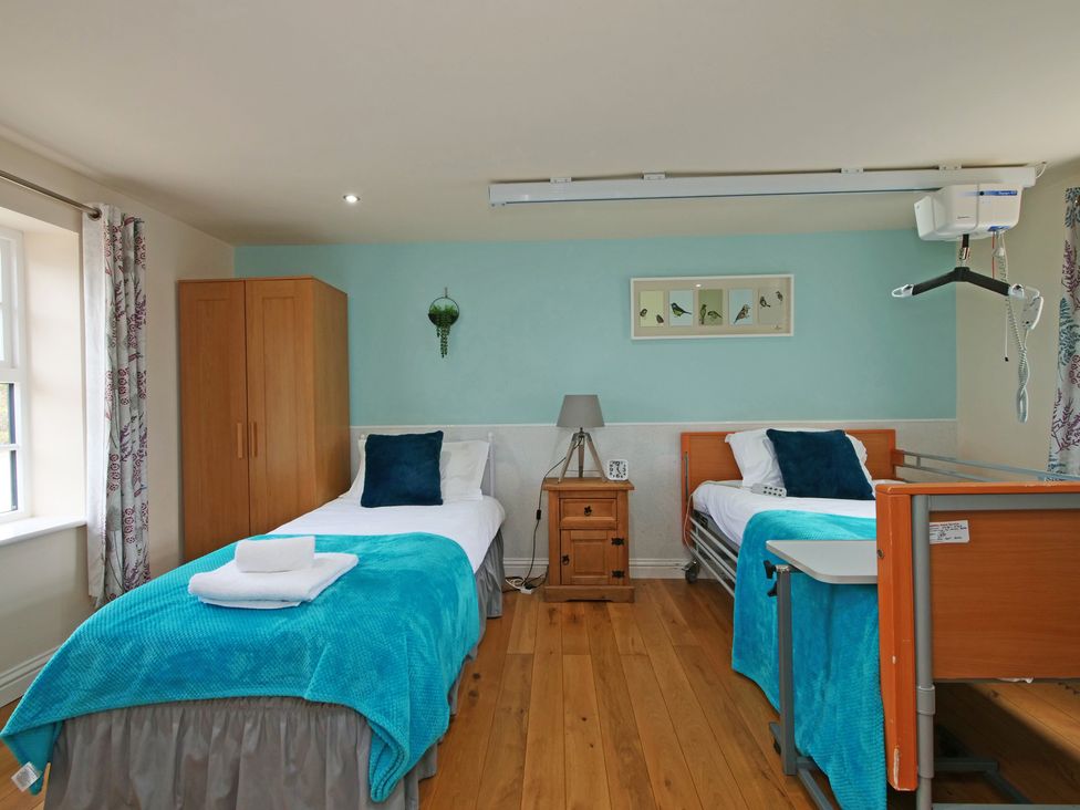 A bedroom with two beds and a wardrobe at Albany @ Summerfield Farm in Hawsker