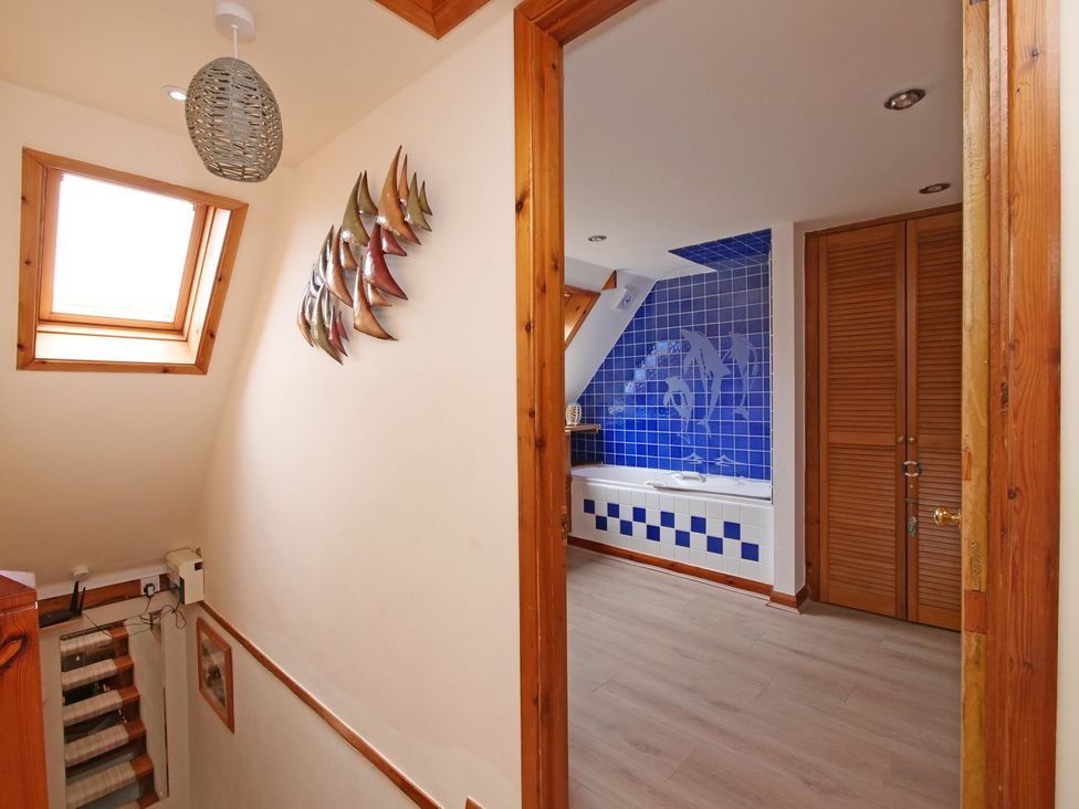 A bathroom with a bathtub and blue tiles at Albany @ Summerfield Farm, Hawsker