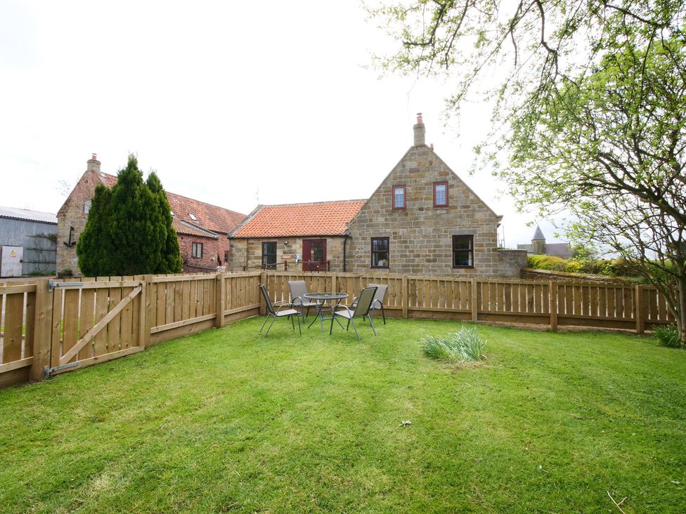 A fenced garden with a table and chairs at Albany @ Summerfield Farm in Hawsker