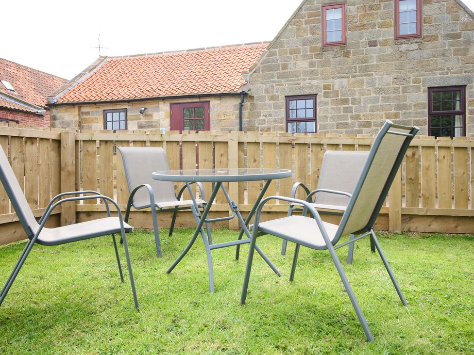 A garden with a table and chairs at Albany @ Summerfield Farm in Hawsker