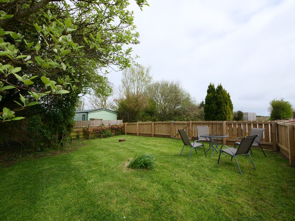 A garden with a table and chairs at Albany @ Summerfield Farm in Hawsker