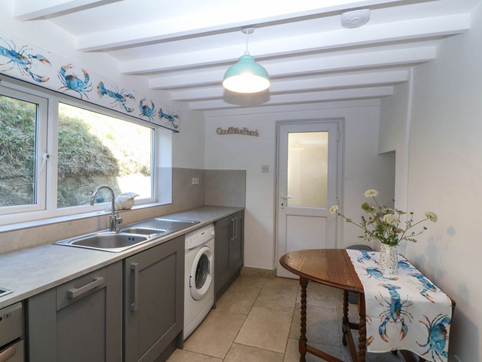 A kitchen with a sink and washing machine at 4 Bryn Llan Aberdaron