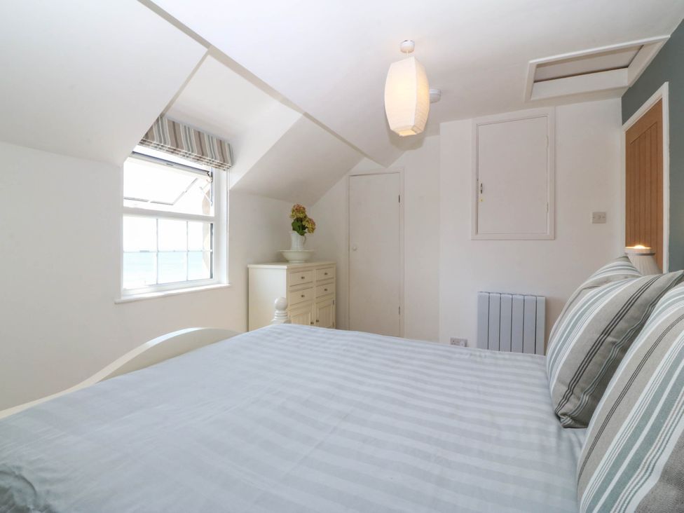 A bedroom with a bed and window at 4 Bryn Llan Aberdaron