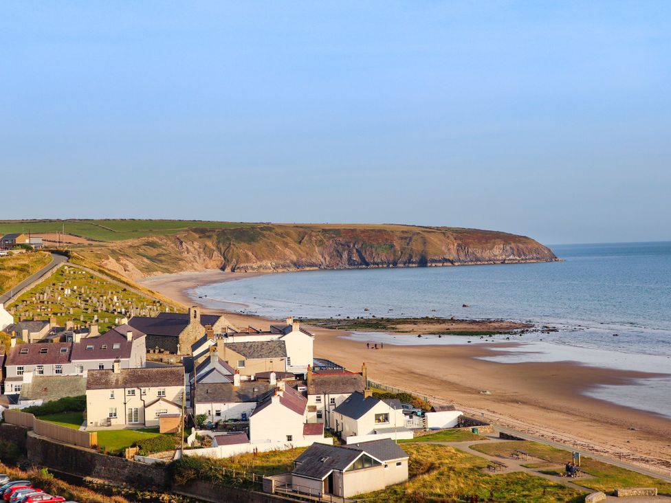 A view of houses and beach along the ocean at 4 Bryn Llan Aberdaron