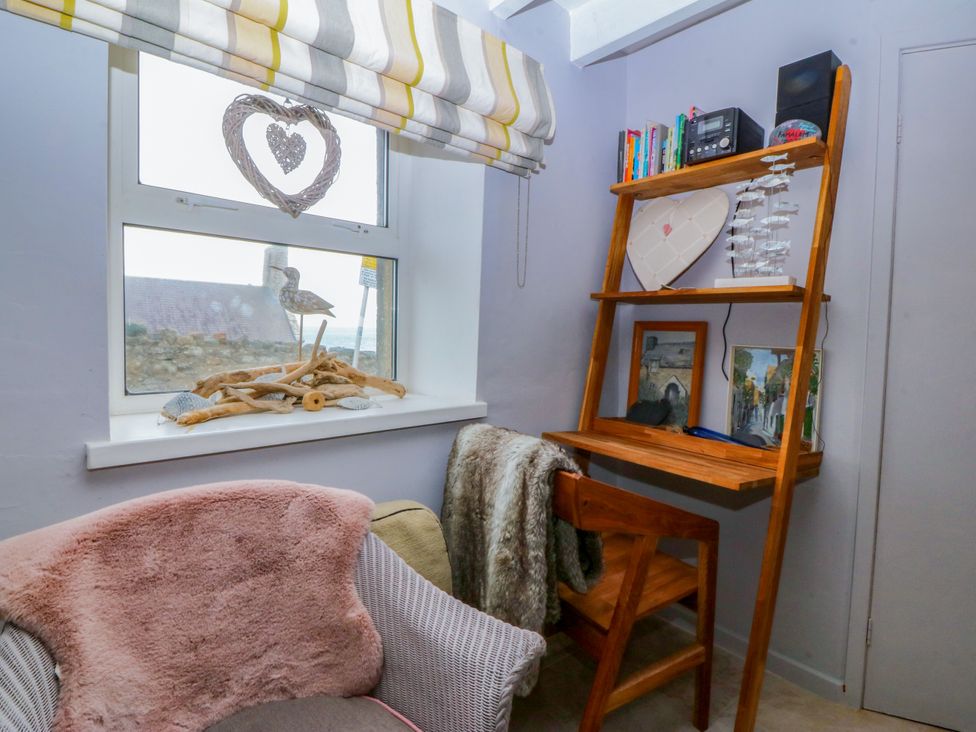 A snug with a chair and shelf in 5 Bryn Llan Pwllheli