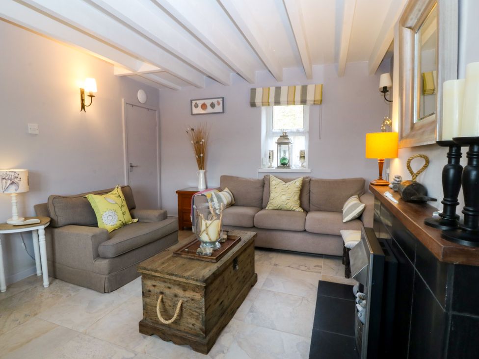 A living room with a sofa and a coffee table at 5 Bryn Llan in Pwllheli