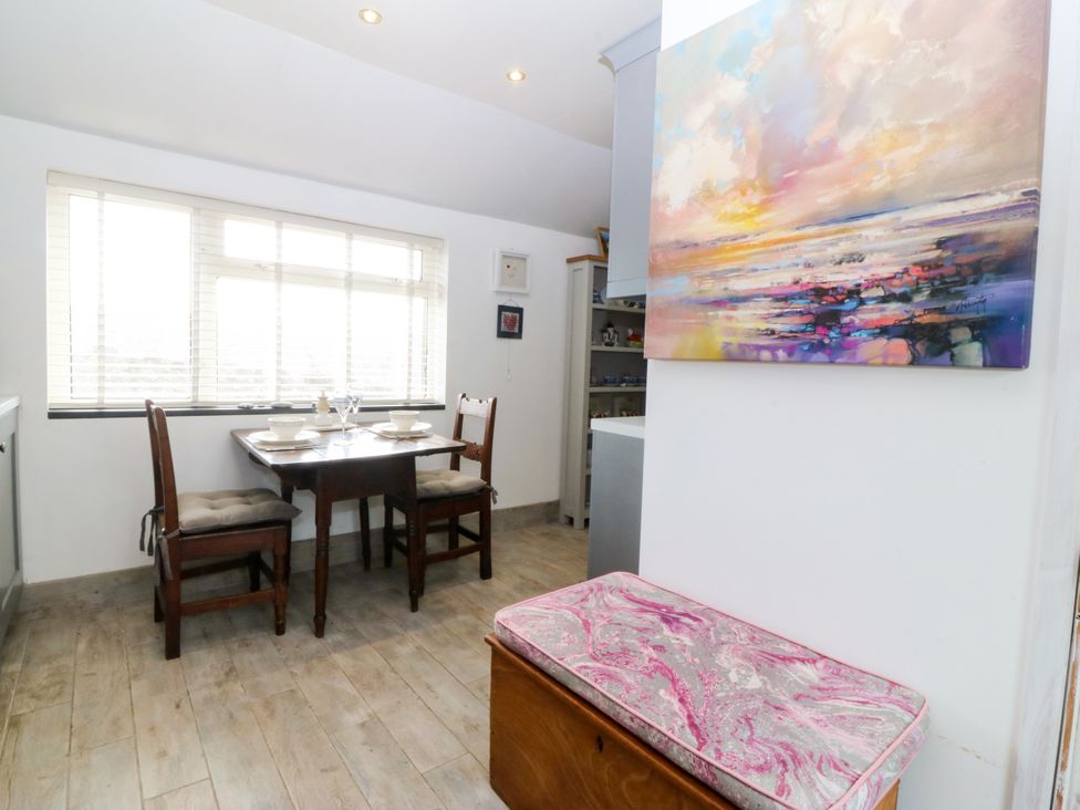 A dining room with a table and chairs at 5 Bryn Llan Pwllheli