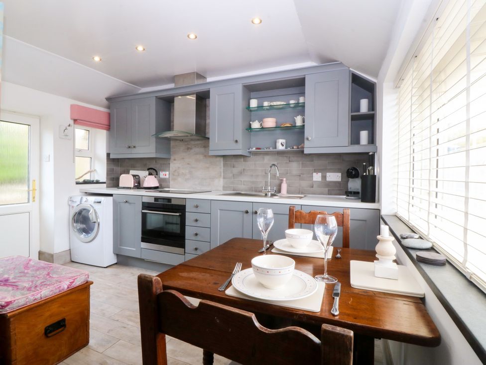 A kitchen with a table set for dining at 5 Bryn Llan Pwllheli