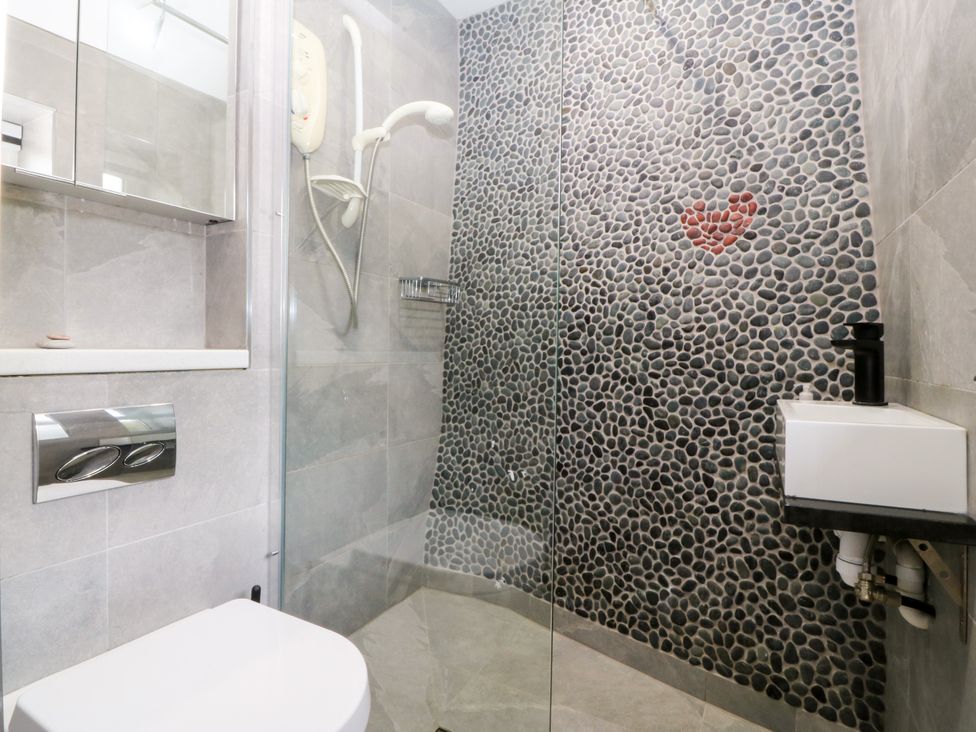 A bathroom with a shower and toilet at 5 Bryn Llan in Pwllheli