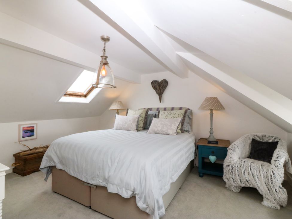 A bedroom with a bed and window at 5 Bryn Llan, Pwllheli