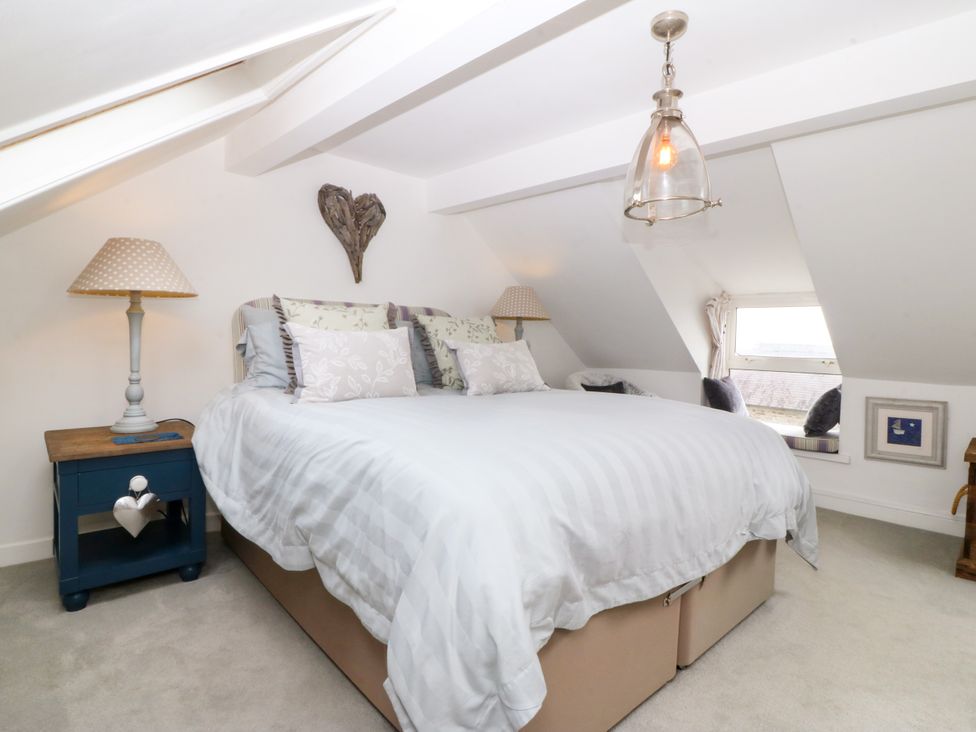A bedroom with a double bed and bedside table at 5 Bryn Llan in Pwllheli