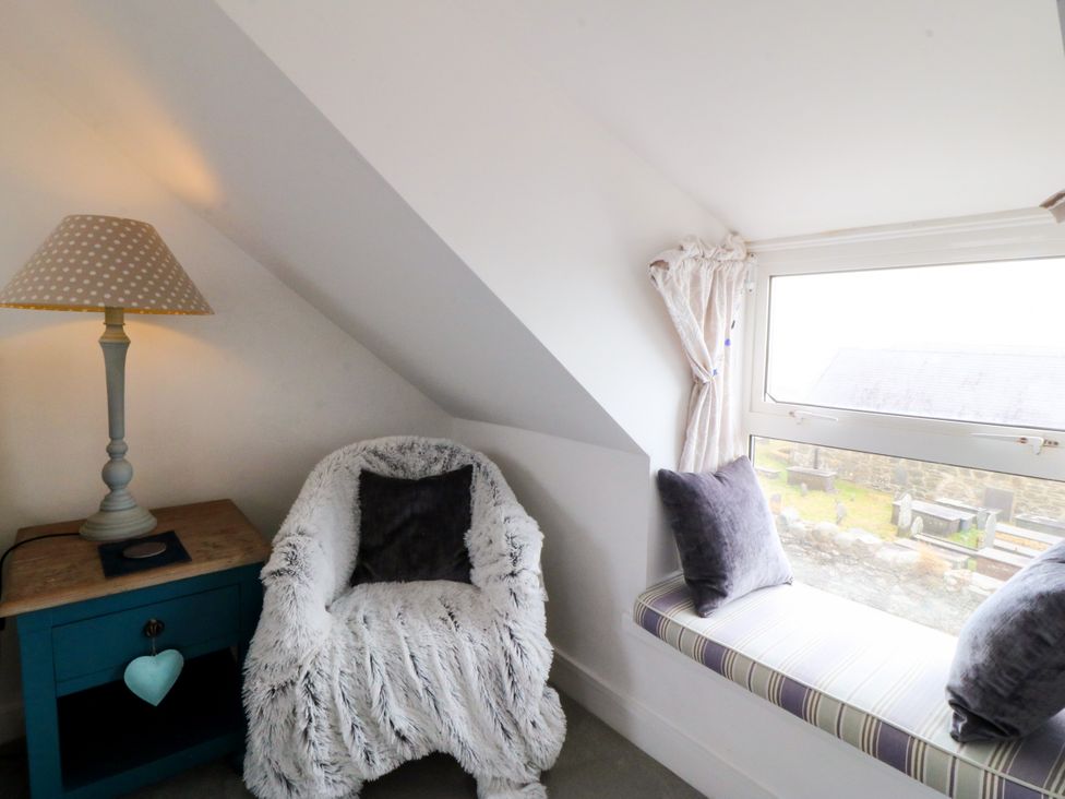 A snug with a chair and lamp at 5 Bryn Llan in Pwllheli