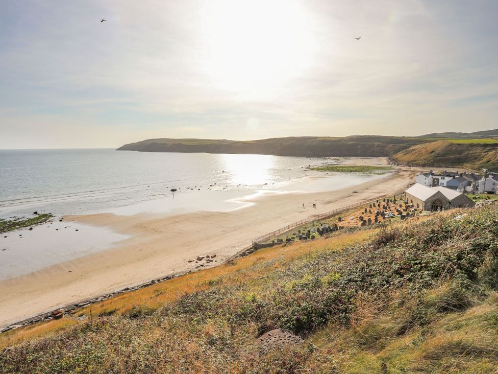 A beach view with sea and distant houses at 5 Bryn Llan Pwllheli