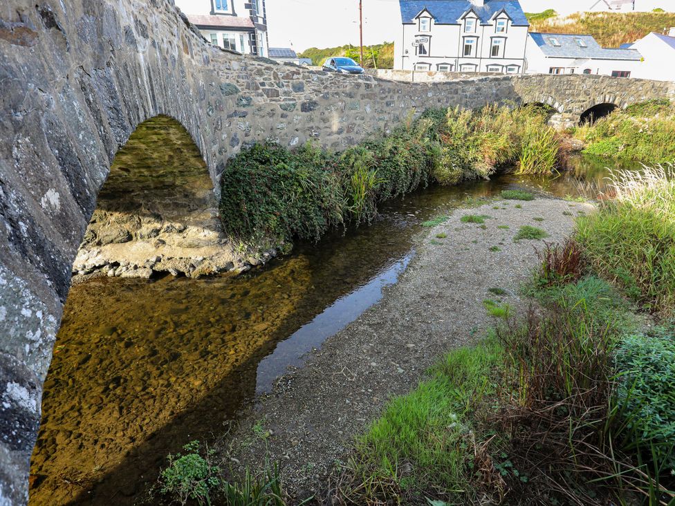 A view of a bridge over a river with houses in the background at 5 Bryn Llan Pwllheli