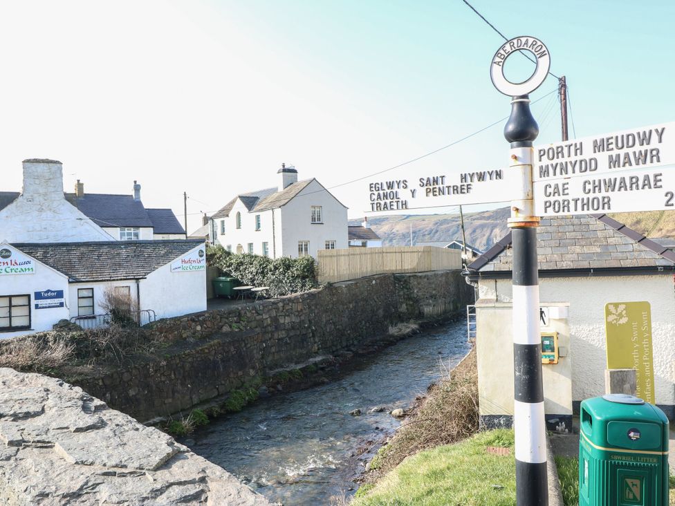 A street view with a signpost and river at 5 Bryn Llan in Pwllheli
