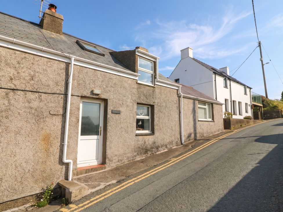 A house on a street with a door and windows at 5 Bryn Llan in Pwllheli