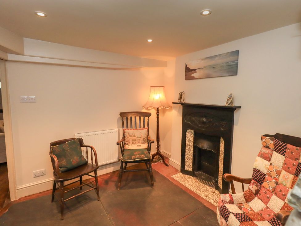 A living room with a fireplace and seating at Bridge End Cottage Haverthwaite near Cartmel