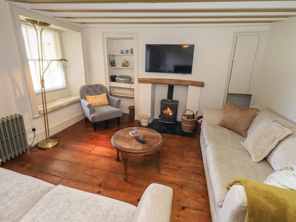 A living room with a fireplace and a television at Bridge End Cottage Haverthwaite near Cartmel