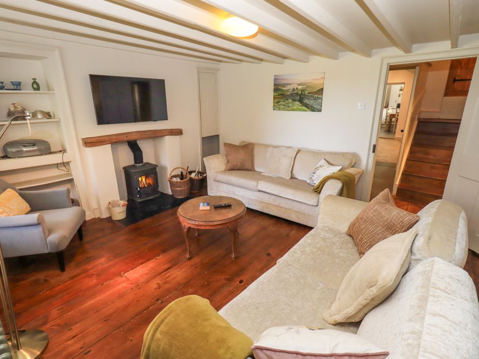 A living room with a fireplace and television at Bridge End Cottage Haverthwaite near Cartmel