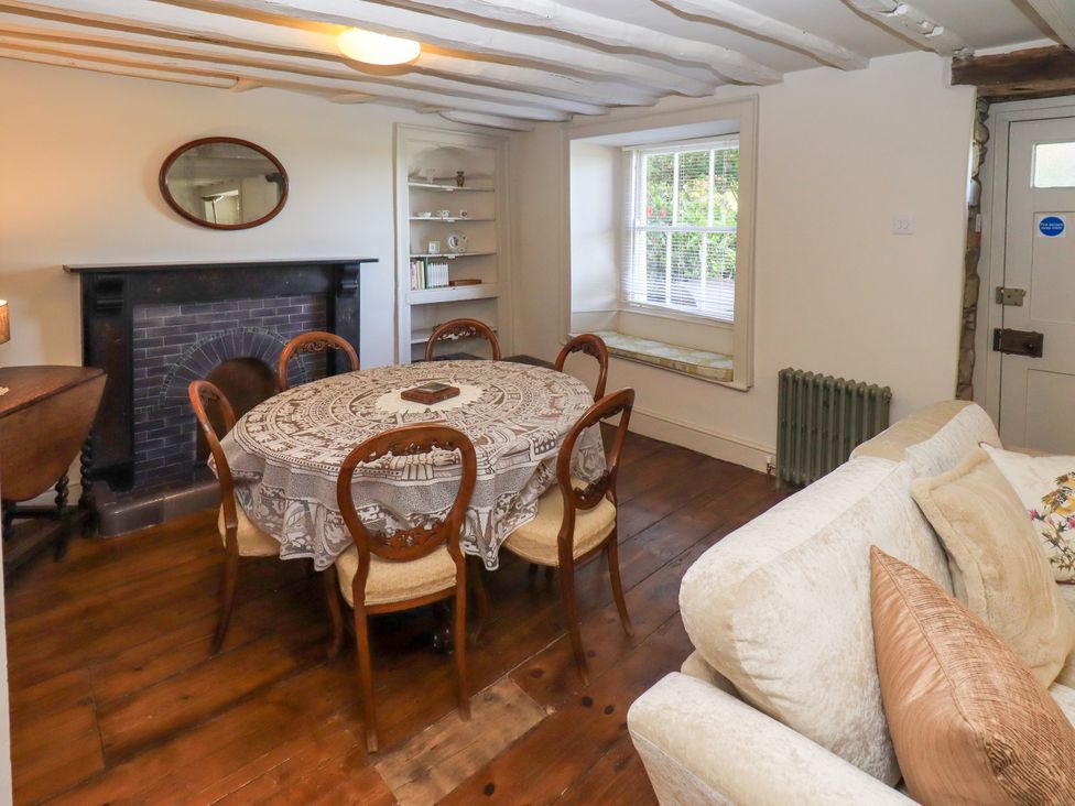 A dining room with a round table and chairs at Bridge End Cottage Haverthwaite near Cartmel