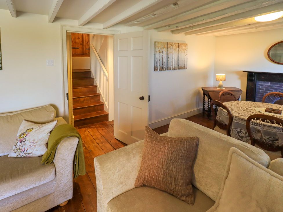 A living room with a sofa and staircase at Bridge End Cottage Haverthwaite near Cartmel