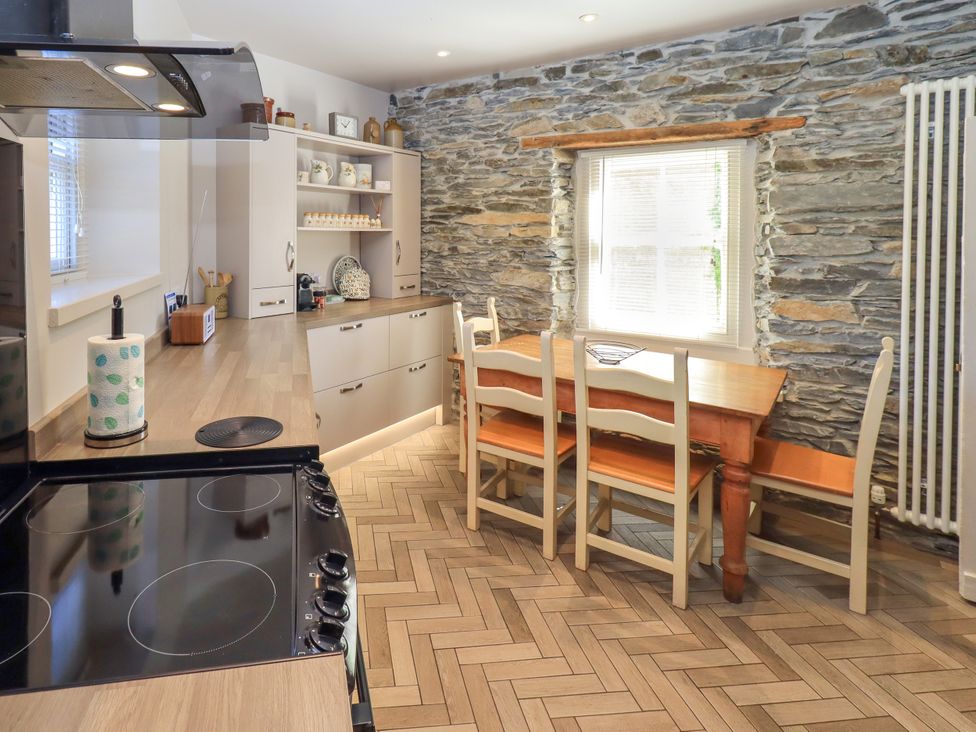 A kitchen with a table and chairs at Bridge End Cottage in Haverthwaite near Cartmel