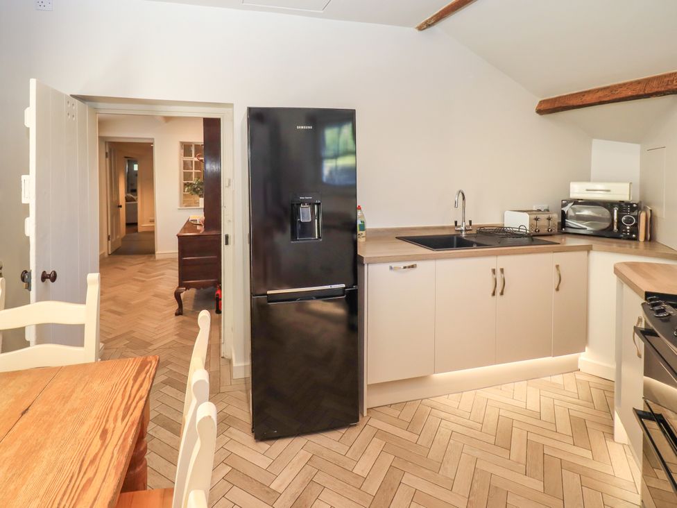 A kitchen with a refrigerator and sink at Bridge End Cottage Haverthwaite near Cartmel