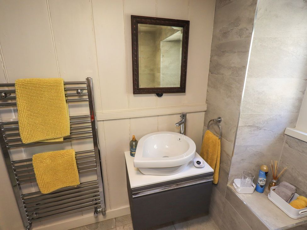 A bathroom with a sink and towel warmer at Bridge End Cottage in Haverthwaite near Cartmel