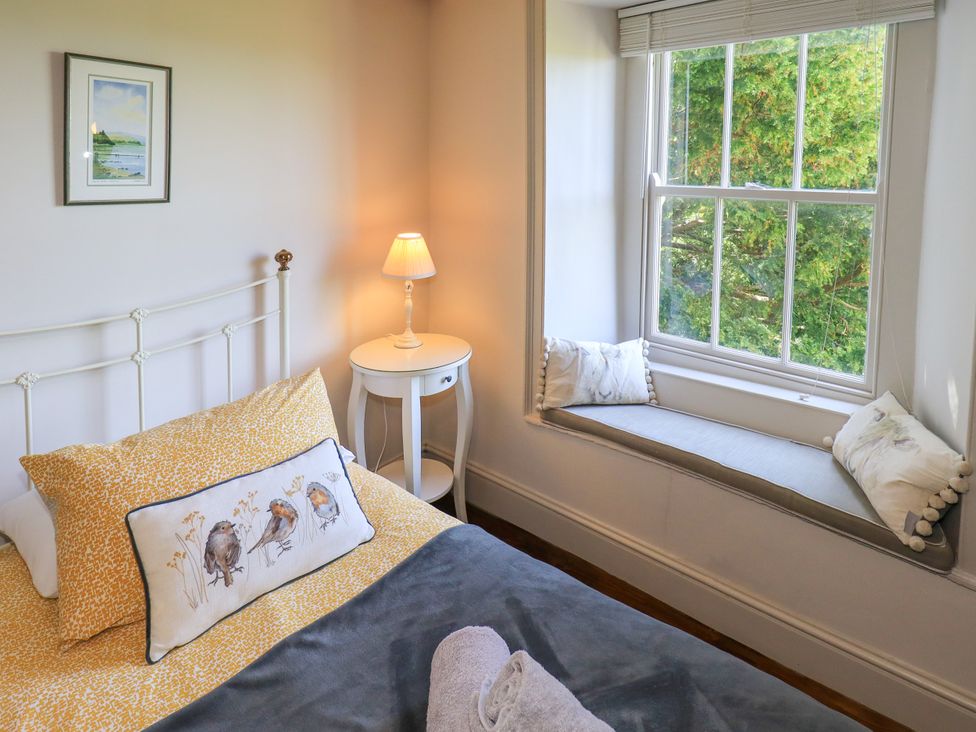 A bedroom with a bed and window seat at Bridge End Cottage Haverthwaite near Cartmel