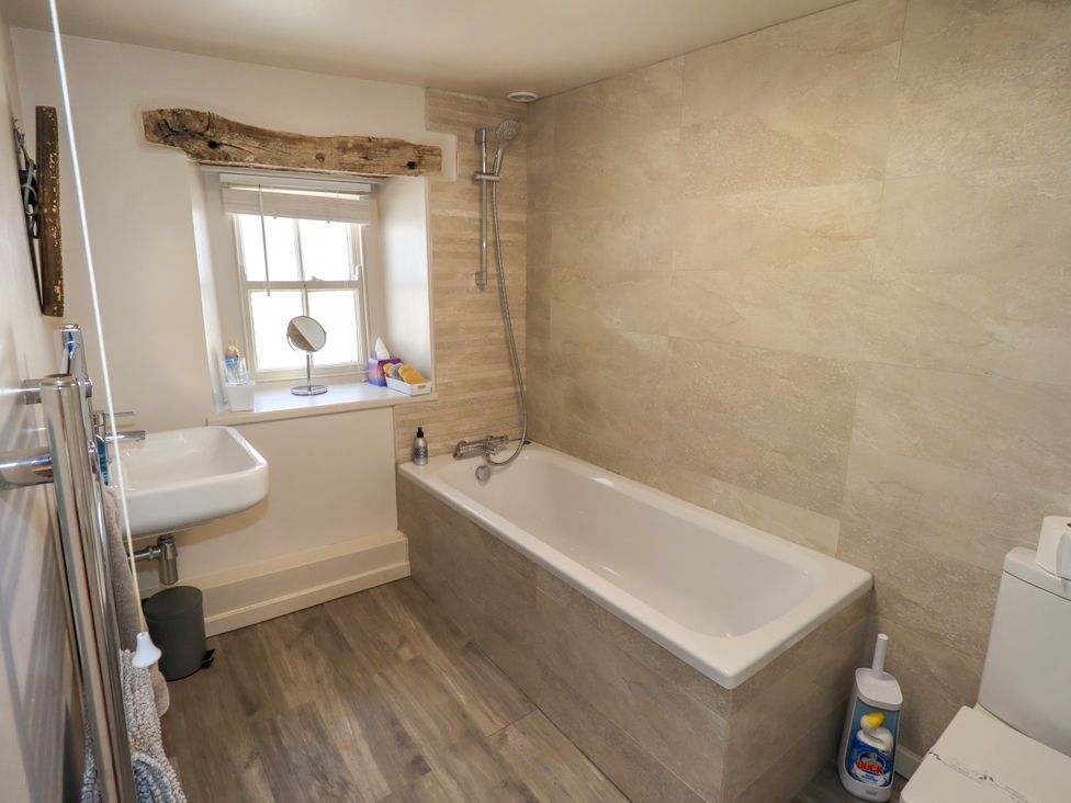 A bathroom with a sink, bathtub and shower at Bridge End Cottage in Haverthwaite near Cartmel