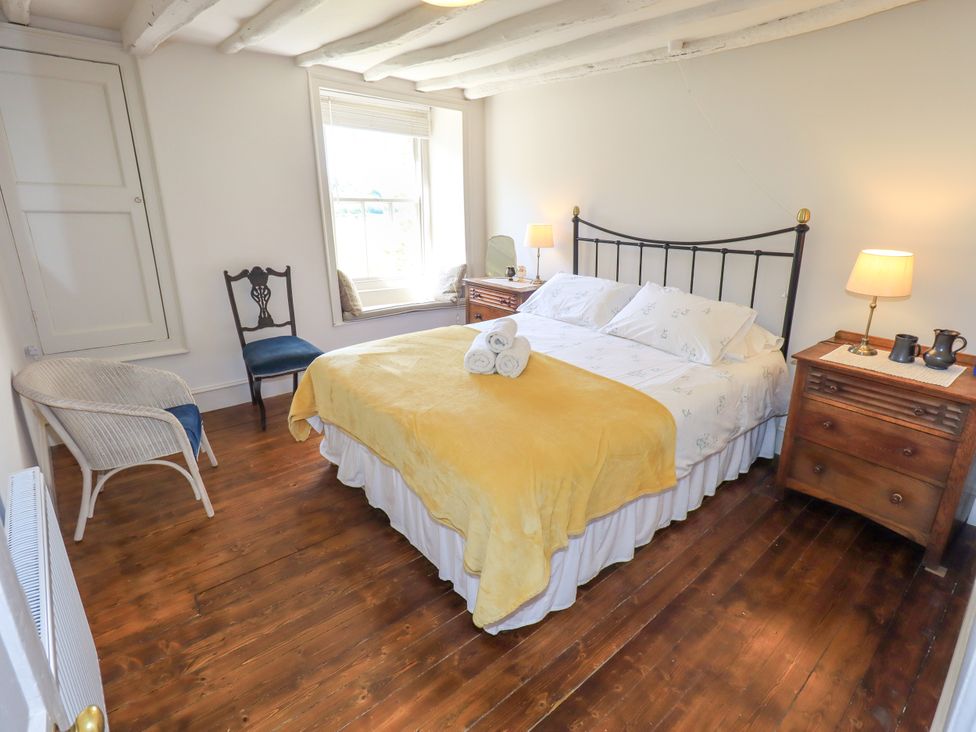 A bedroom with a bed and nightstand at Bridge End Cottage Haverthwaite near Cartmel